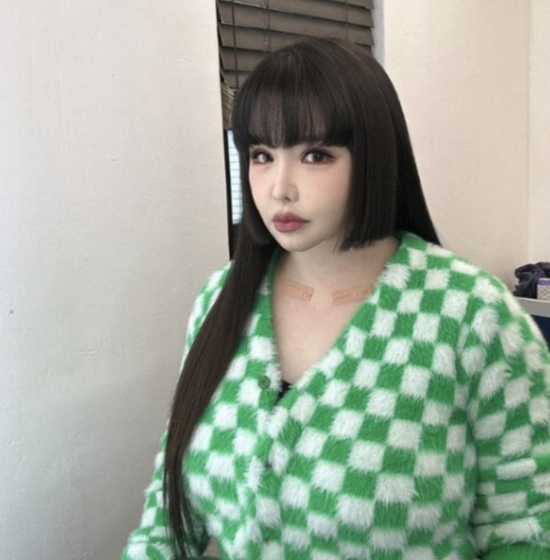 Park Bom, with a new hairstyle... the band aid seen on her collarbone